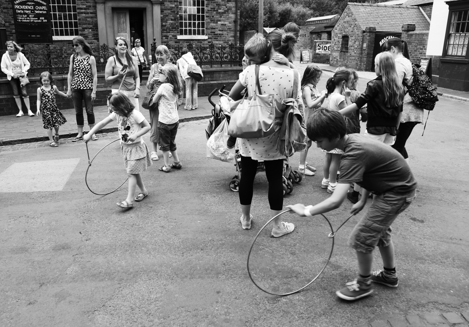 Children playing with metal hoop toys 1900s